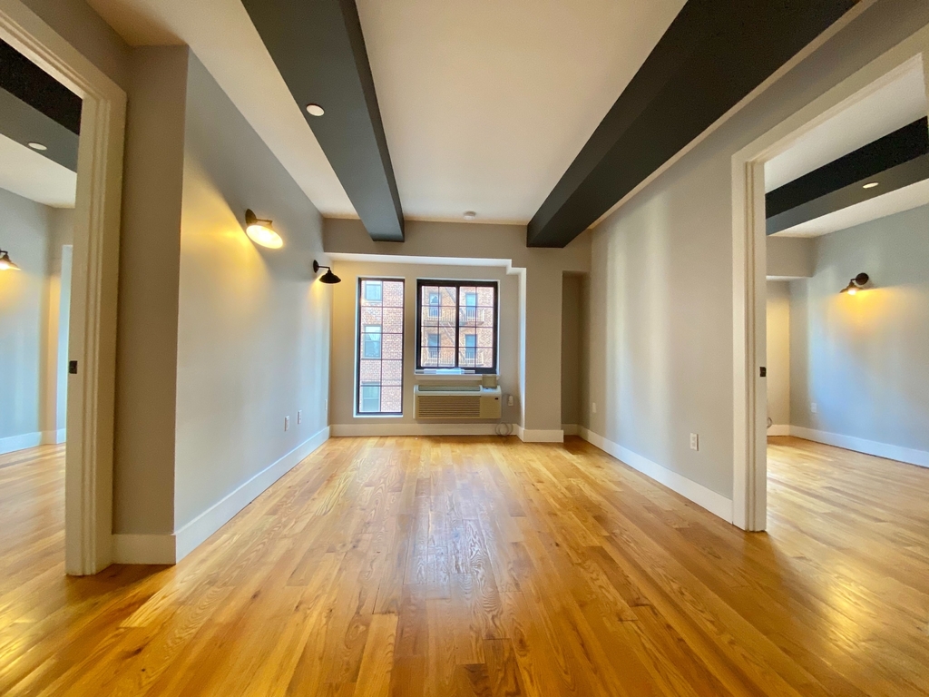 Living room with large windows and exposed beams in Brooklyn