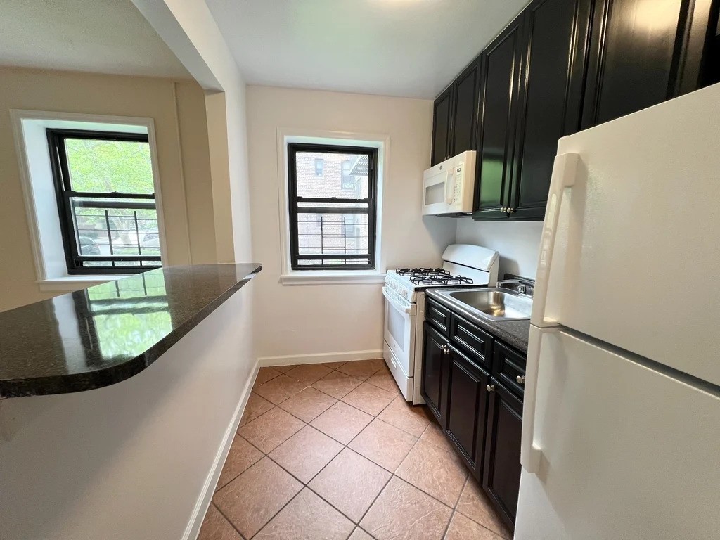 Queens windowed kitchen with dark cabinets