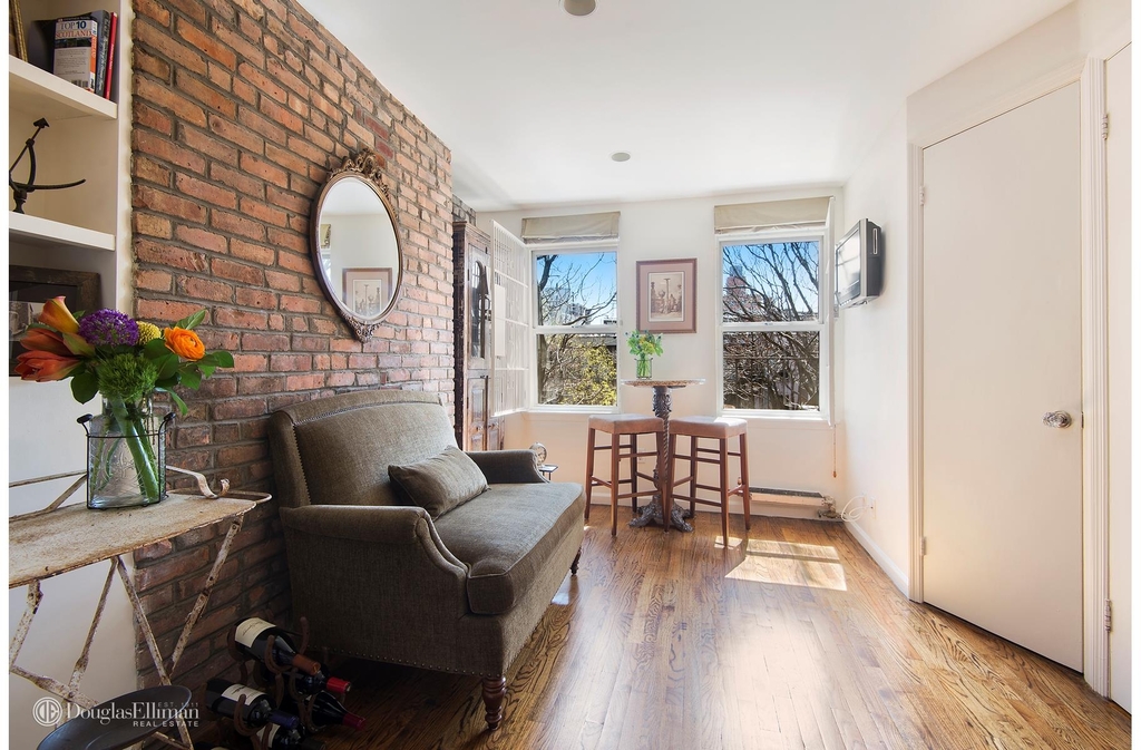 Living room with exposed brick and a window