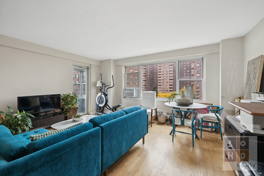 Living room with a blue couch and large windows