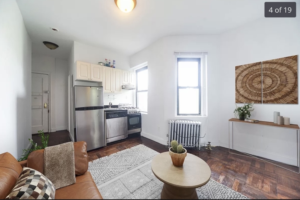 photo of living room with kitchen in the background